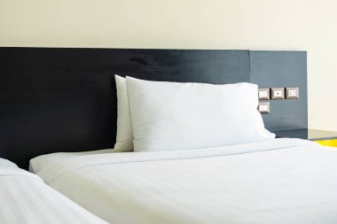 Yastık ve battaniye yatağın üzerinde, içinde lamba süslemesi var.