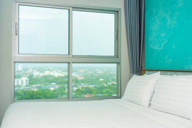 Yastık ve battaniye yatağın üzerinde, içinde lamba süslemesi var.