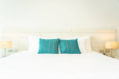 Yastık ve battaniye yatağın üzerinde, içinde lamba süslemesi var.