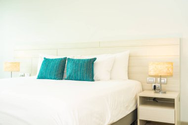 Yastık ve battaniye yatağın üzerinde, içinde lamba süslemesi var.