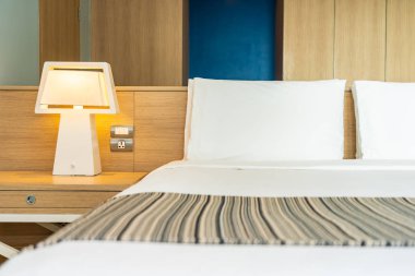 Yastık ve battaniye yatağın üzerinde, içinde lamba süslemesi var.