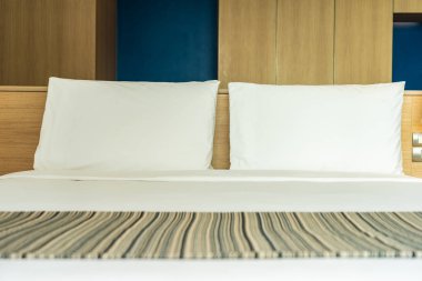 Yastık ve battaniye yatağın üzerinde, içinde lamba süslemesi var.