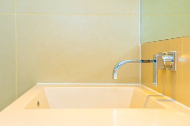 Banyoda musluk desenli beyaz lavabo.