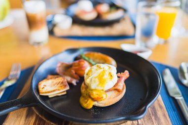 Sıcak tavada yumurtalı Benedict sosisi ile kahvaltı.