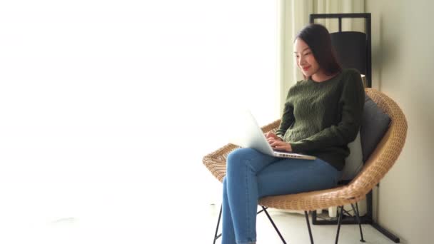 집에서 노트북을 가지고 일하는 아름다운 이시아 여성의 — 비디오