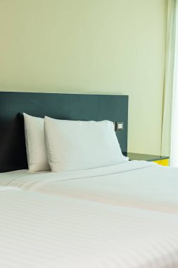 Yastık ve battaniye yatağın üzerinde, içinde lamba süslemesi var.