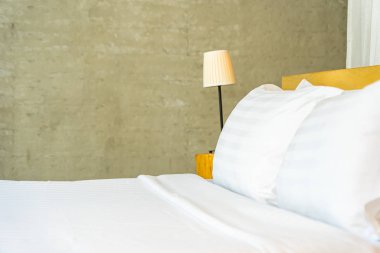 Yastık ve battaniye yatağın üzerinde, içinde lamba süslemesi var.