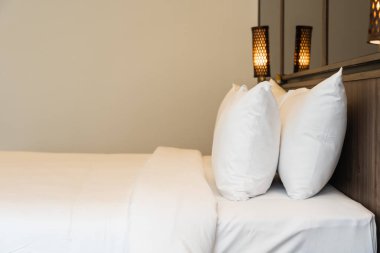 Yastık ve battaniye yatağın üzerinde, içinde lamba süslemesi var.