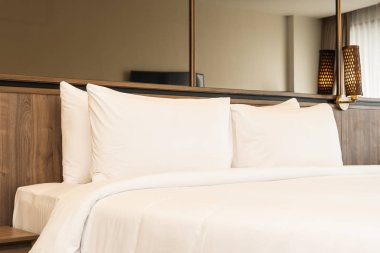 Yastık ve battaniye yatağın üzerinde, içinde lamba süslemesi var.