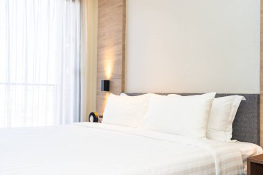 Yatak dekorasyonunda beyaz rahat yastık.