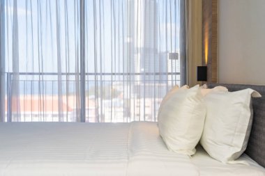 Yatak dekorasyonunda beyaz rahat yastık.