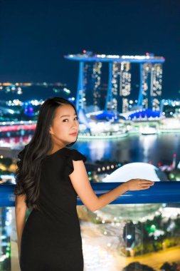 Güzel Asyalı kadınlar gülümseme ve mutlu Singapur şehir manzaralı