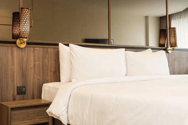 Подушка и одеяло на кровати со светлой лампой украшения интерьера — стоковое фото