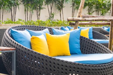 Bahçedeki verandada kanepe ve yastık dekorasyonu var.