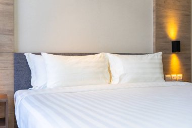 Yatak dekorasyonunda beyaz rahat yastık.