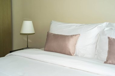 Yatak dekorasyonunda beyaz rahat yastık.