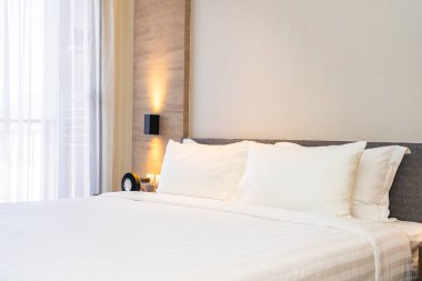 Yatak dekorasyonunda beyaz rahat yastık.