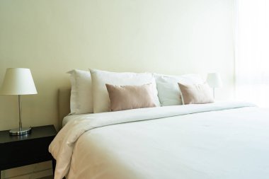 Yatak dekorasyonunda beyaz rahat yastık.