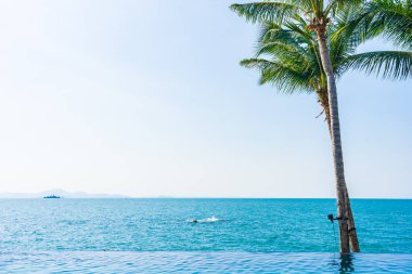 Otelin havuzunda hindistan cevizi palmiyeli lüks bir yüzme havuzu.