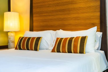 Yatak dekorasyonunda beyaz rahat yastık.