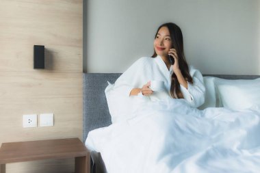 Güzel Asyalı genç kadınların portresi Kahveyle mutlu bir gülümseme ve