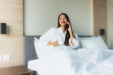 Güzel Asyalı genç kadınların portresi Kahveyle mutlu bir gülümseme ve