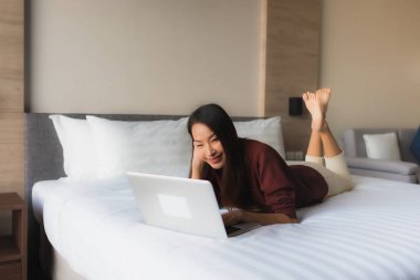 Bilgisayar ve cep telefonu kullanan güzel Asyalı genç kadınların portresi.