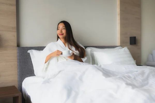 Porträt schöne junge asiatische Frauen mit Kaffeetasse auf dem Bett — Stockfoto