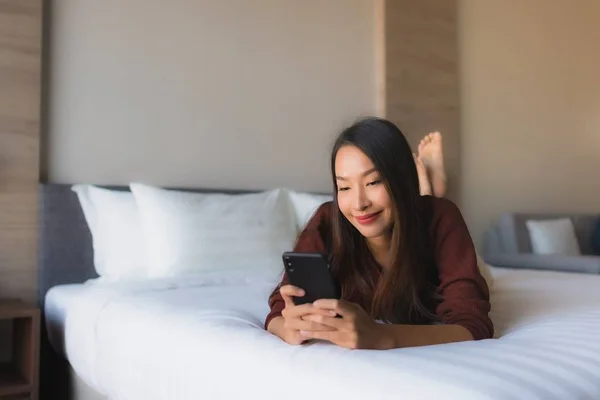 Portrait belles jeunes femmes asiatiques en utilisant le téléphone mobile sur le lit — Photo