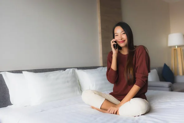 Porträt schöne junge asiatische Frauen mit Handy auf dem Bett — Stockfoto