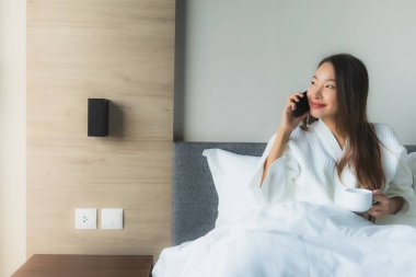 Güzel Asyalı genç kadınların portresi Kahveyle mutlu bir gülümseme ve