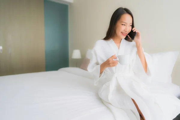 Porträt schöne junge asiatische Frauen mit Kaffeetasse und Handy — Stockfoto