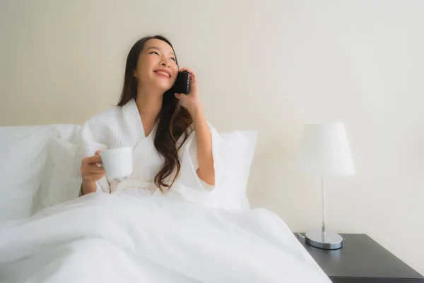 Porträt schöne junge asiatische Frauen mit Kaffeetasse und Handy — Stockfoto