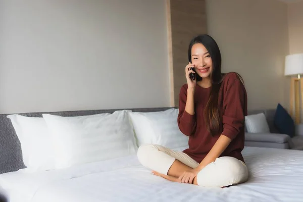 Retrato hermosa joven asiático mujeres utilizando el teléfono móvil en la cama — Foto de Stock