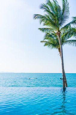 Otelin havuzunda hindistan cevizi palmiyeli lüks bir yüzme havuzu.