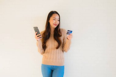 Güzel genç Asyalı portresi. Credi ile cep telefonu kullan.