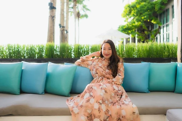 Porträtt vackra unga asiatiska kvinnor glad leende sitta på soffa aro — Stockfoto