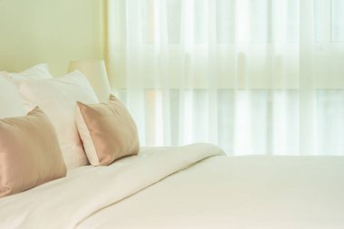 Yatak dekorasyonunda beyaz rahat yastık.