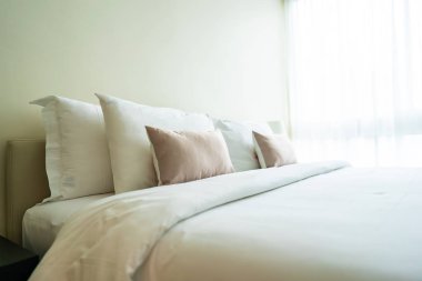 Yatak dekorasyonunda beyaz rahat yastık.