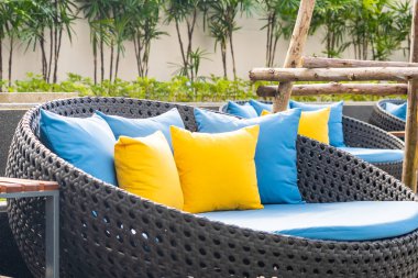 Bahçedeki verandada kanepe ve yastık dekorasyonu var.