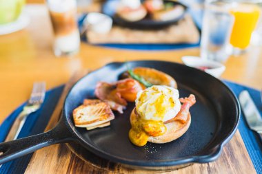 Sıcak tavada yumurtalı Benedict sosisi ile kahvaltı.