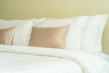 Yatak dekorasyonunda beyaz rahat yastık.