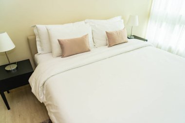 Yatak dekorasyonunda beyaz rahat yastık.