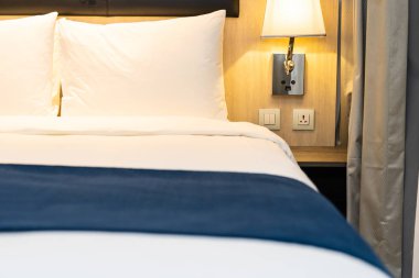 Yatak odasındaki beyaz rahat yastık ve battaniye