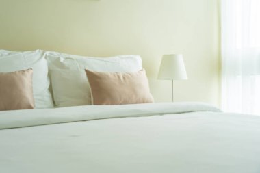 Yatak dekorasyonunda beyaz rahat yastık.