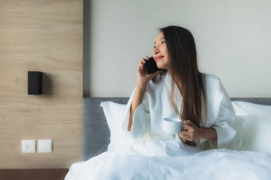 Güzel Asyalı genç kadınların portresi Kahveyle mutlu bir gülümseme ve