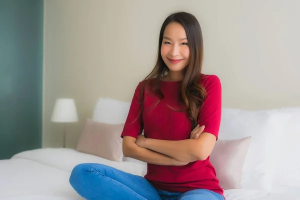 Porträtt vackra unga asiatiska kvinnor ler glad på sängen — Stockfoto