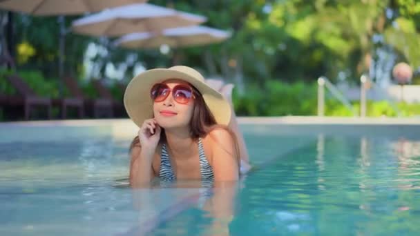 美丽的年轻亚洲女人在游泳池里放松 — 图库视频影像