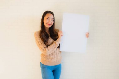 Güzel Asyalı genç kadınların portresi boş beyaz kağıt yaban domuzu gösteriyor.