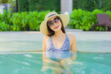 Güzel, genç Asyalı kadınlar mutlu gülüşler açık havada yüzüyorlar.